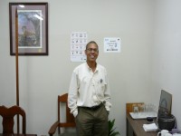 the CEO of the Belize Chamber of Commerce stands smiling in the conference room