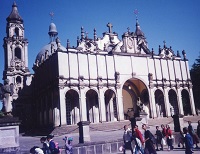 a large white stone building with arches and a multi-tiered tower