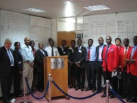 DevPar consultant stands with USE representatives and newly-trained securities dealers in their red jackets