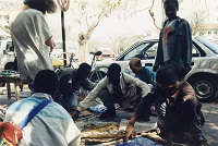 customers inspect the cloth wares of a street vendor